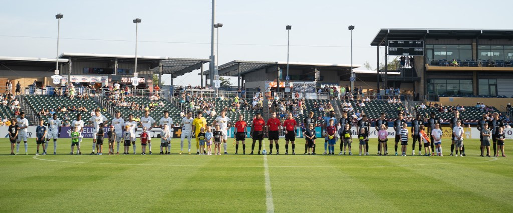 Hailstorm and Union Omaha line up for the National Anthem ahead of kick off from Werner Park